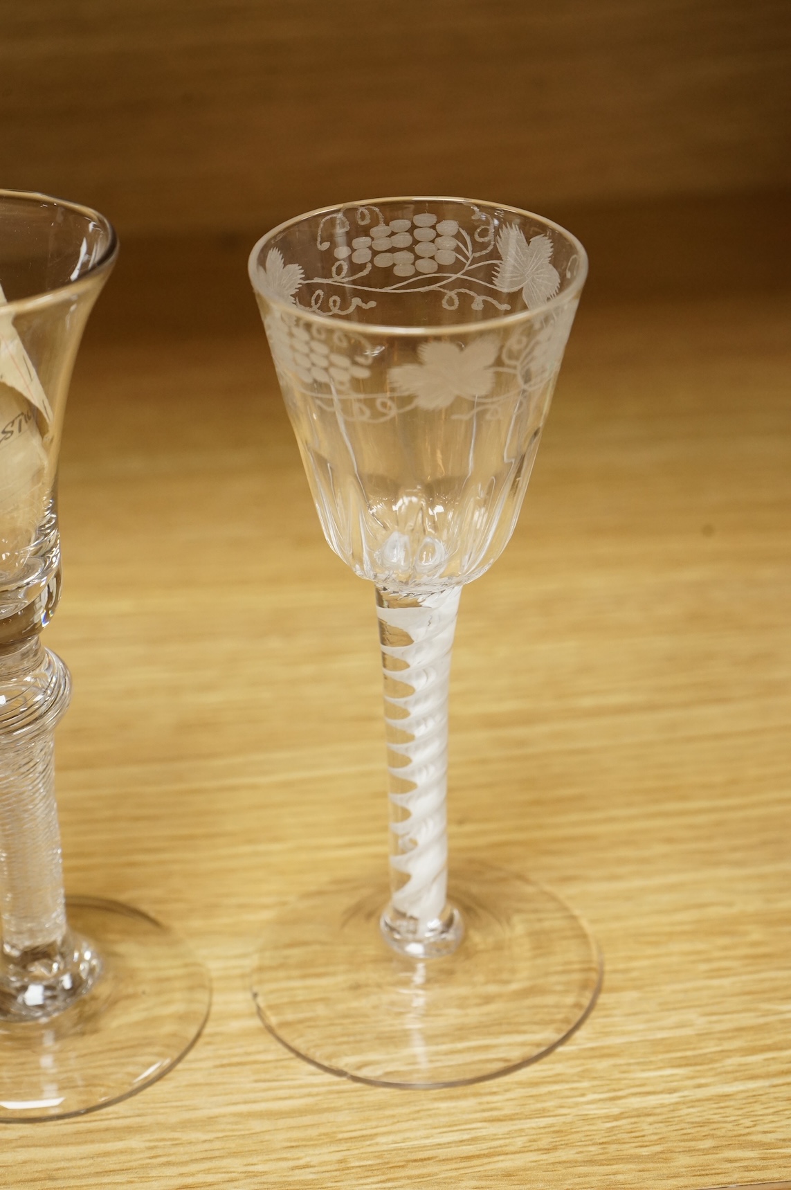Two Georgian wine glasses, one with air twist stem and etched decoration to the bowl, largest 16cm high